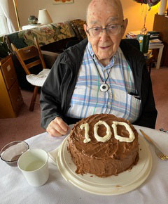 Herbert Alden McKinstry sitting behind his 100th birthday cake
