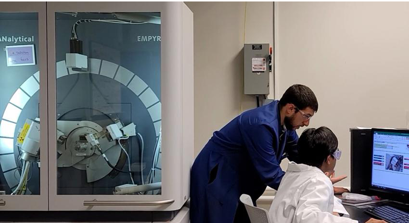 Gino Tambourine, technical staff, X-ray/particle/thermal with the Materials Research Institute (MRI), mentors Muhammad Ishak, third-year materials science and engineering and MRI Undergraduate Fellow, on reading research data. Credit: Seana Wood/Penn State MRI